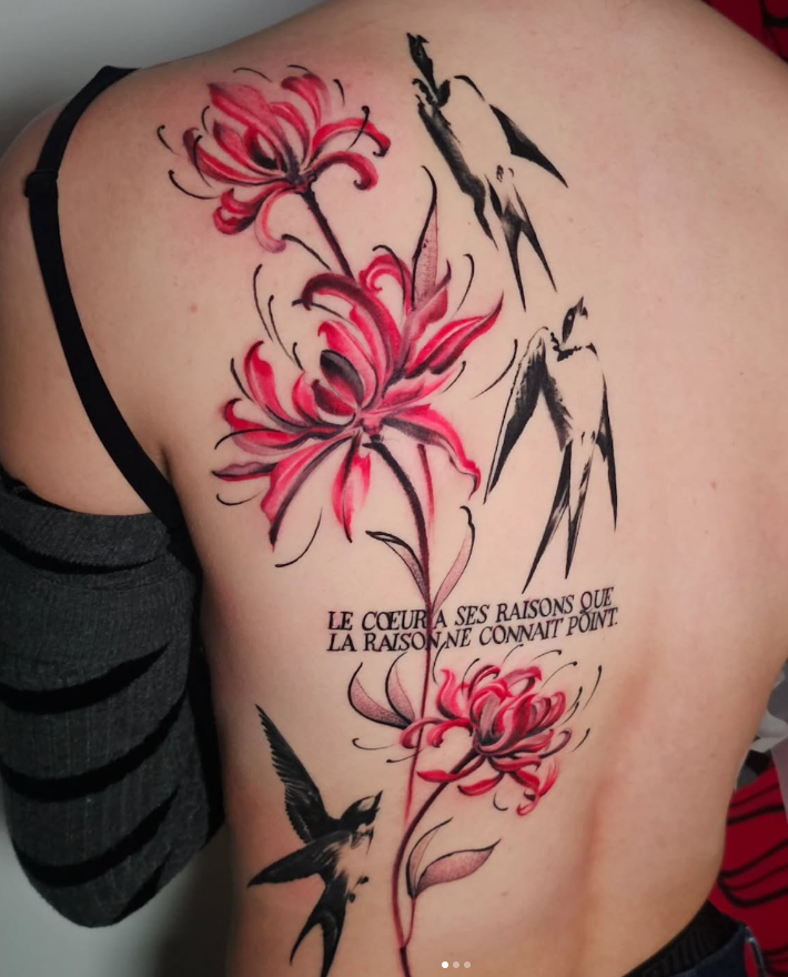 Tatouage floral lycoris rouges et hirondelles sur le dos, réalisé par Gabriel, tatoueur à Bayonne